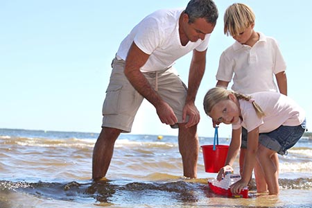 Father playing with his kids on a beach